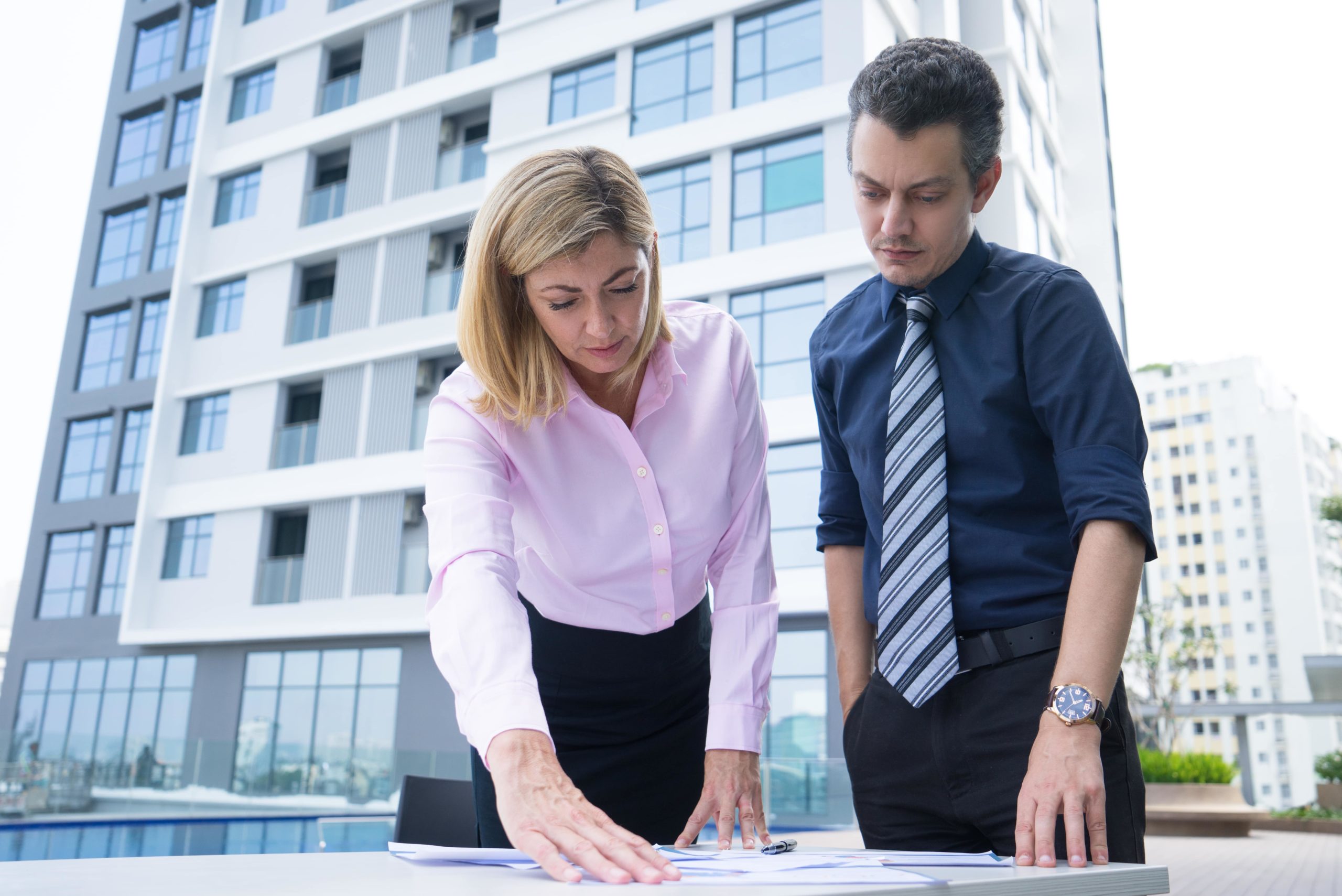 concentrated-thoughtful-business-colleagues-standing-near-table-analyzing-documents-min Commercial Loan Specialist