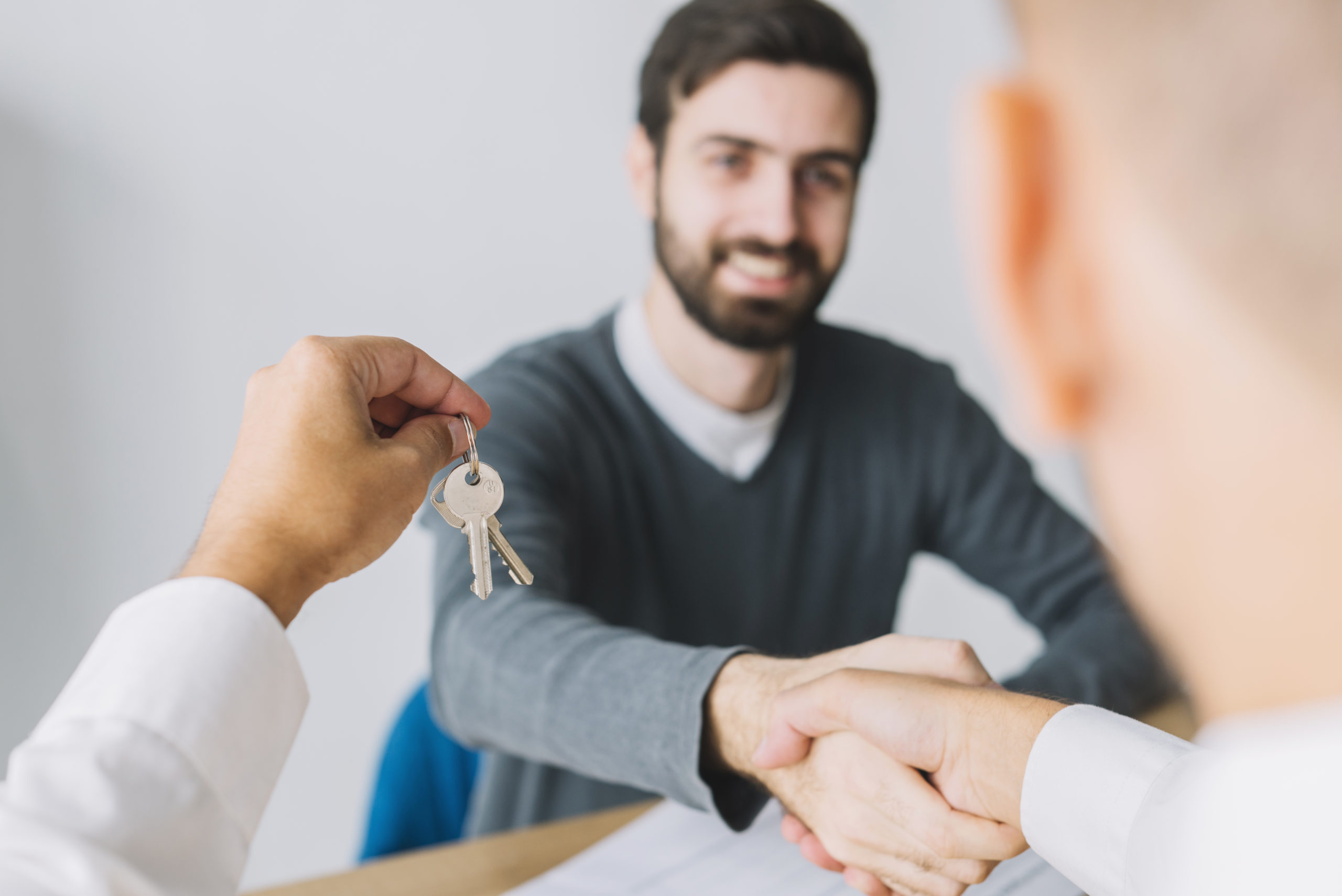 real-estate-agent-shaking-hand-client-holding-keys